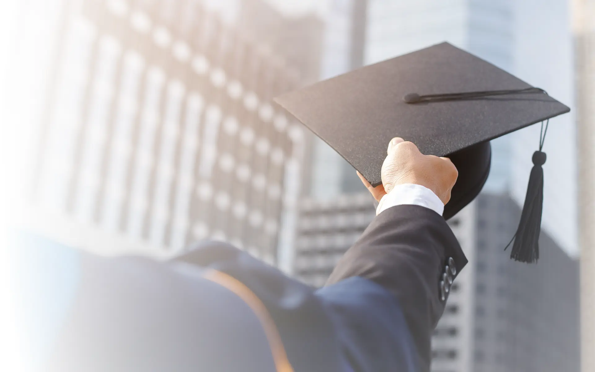 A student raising the cap of his graduation gown.