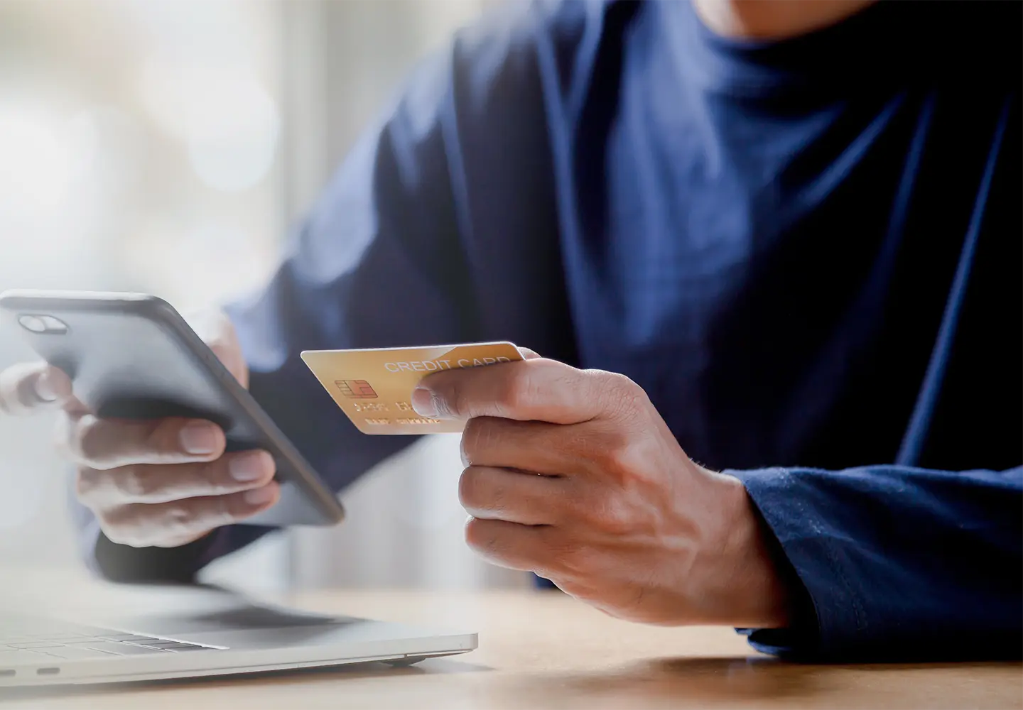 A man holding a card and a mobile.