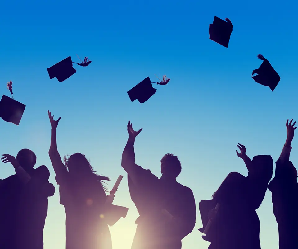 Some students raising the cap of their graduation gown.